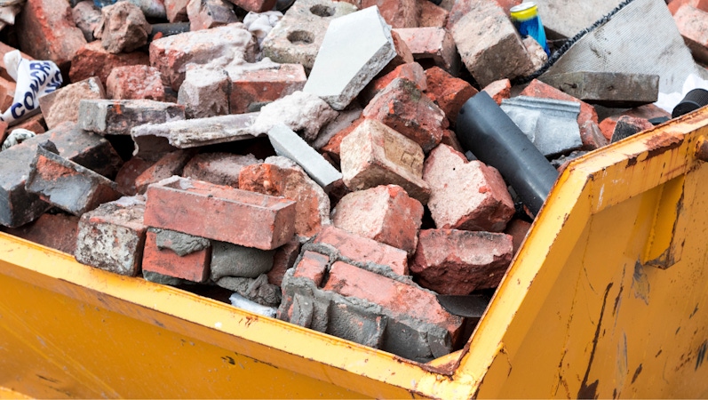 Construction waste in a skip showing bricks and concrete stock image